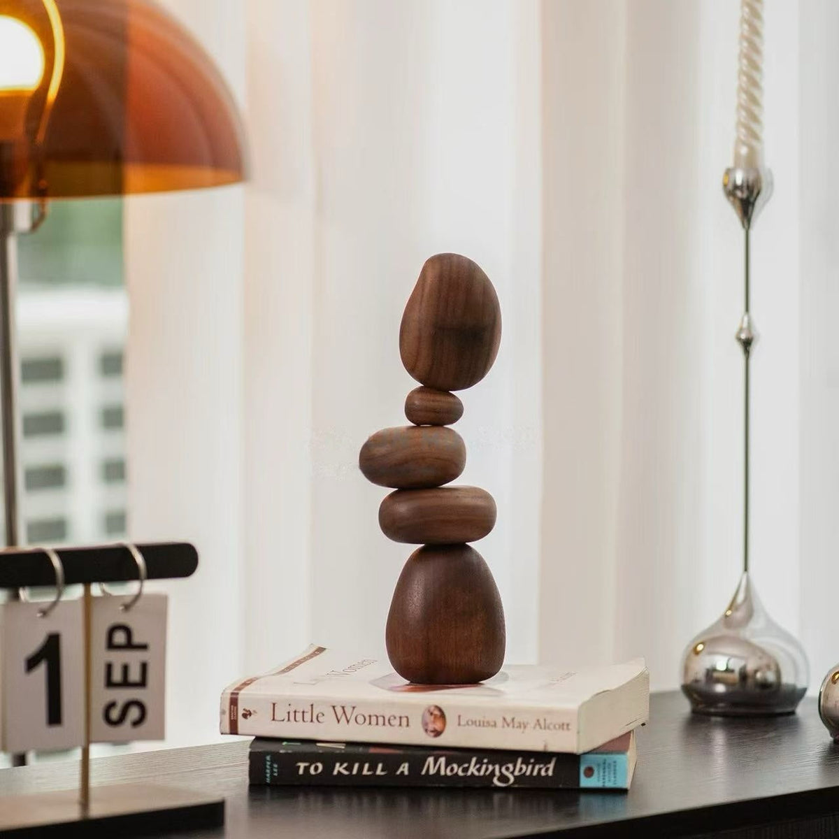 Black Walnut magnetic balance stones displayed on stacked books as modern Zen desk decor