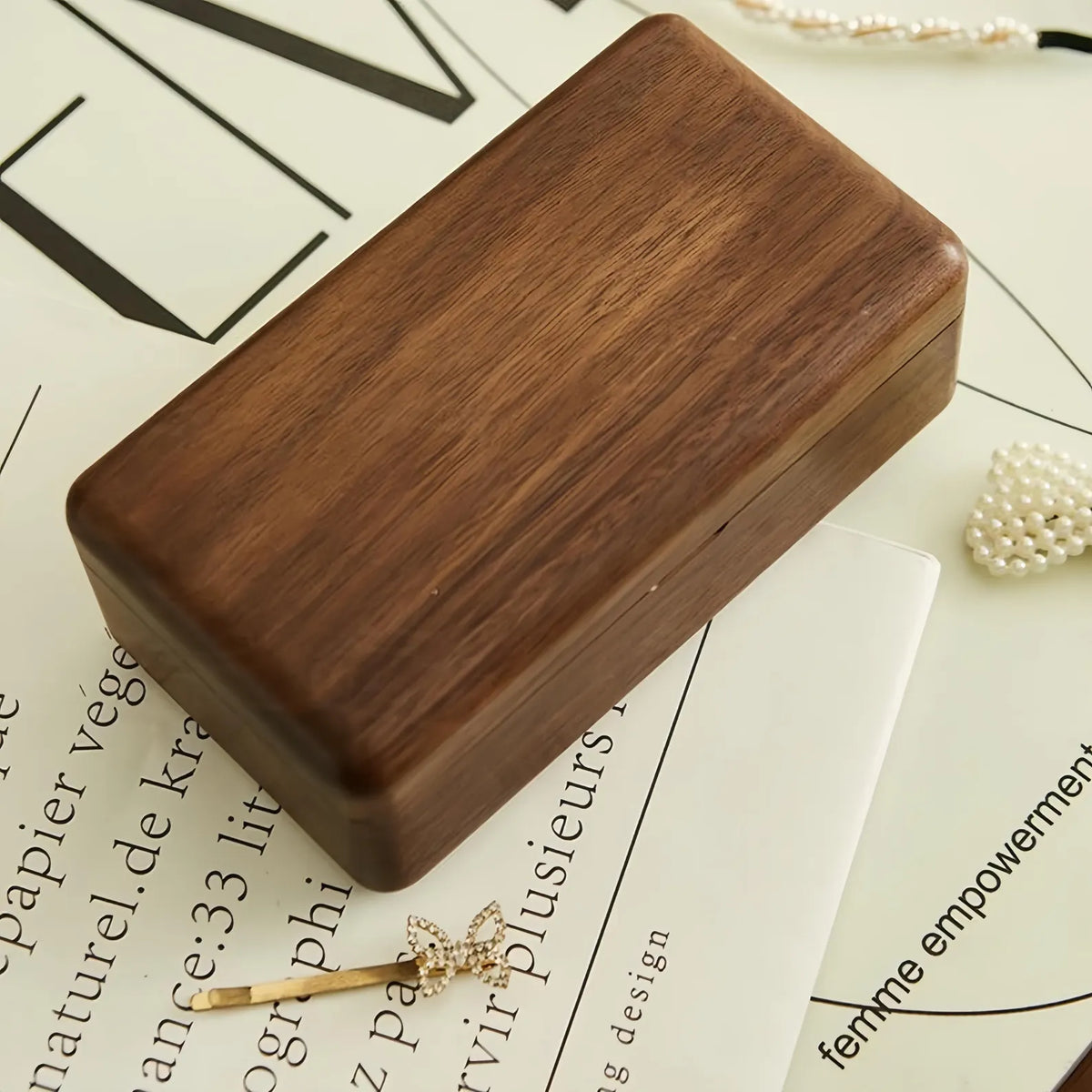 Closed solid black walnut jewelry box with natural wood grain and softly rounded corners