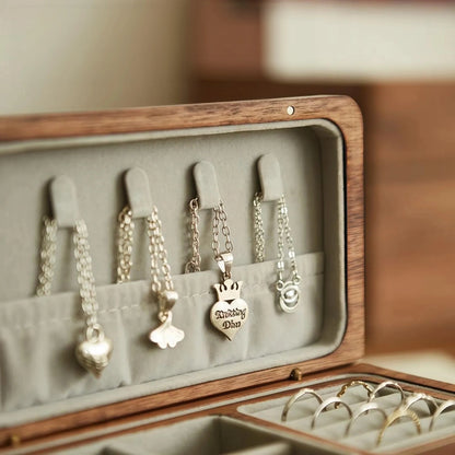 Close-up of velvet-lined necklace hooks and storage pocket inside the black walnut jewelry box lid