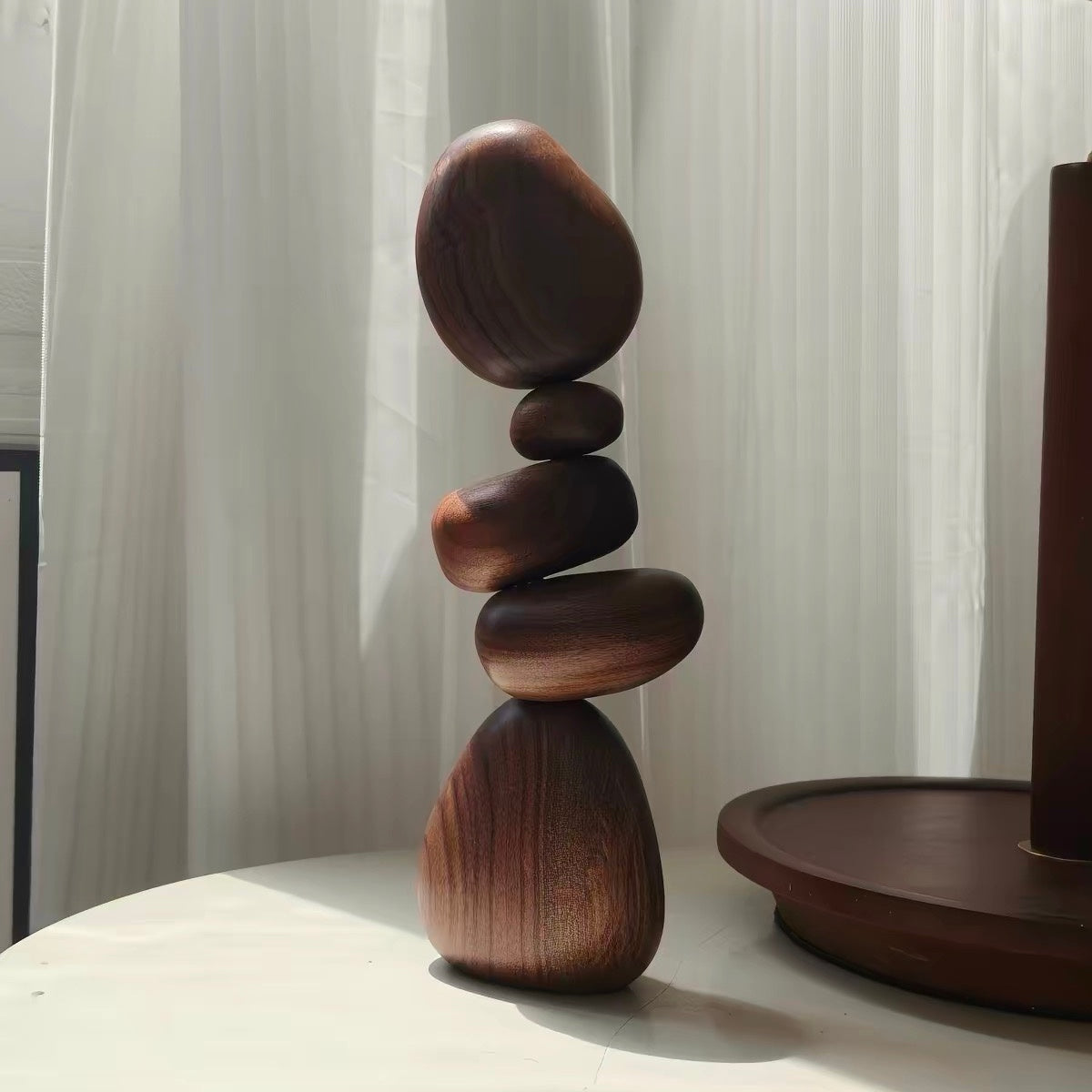 Black Walnut magnetic wooden balance stones arranged on a tabletop beside a wooden tray