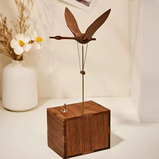 Black walnut swan sculpture displayed beside a flower vase