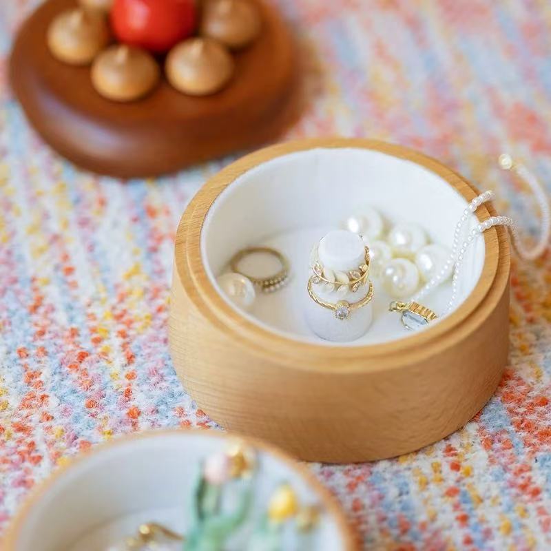 Open cherry cake jewelry box showing white jewelry compartments with rings and pearls