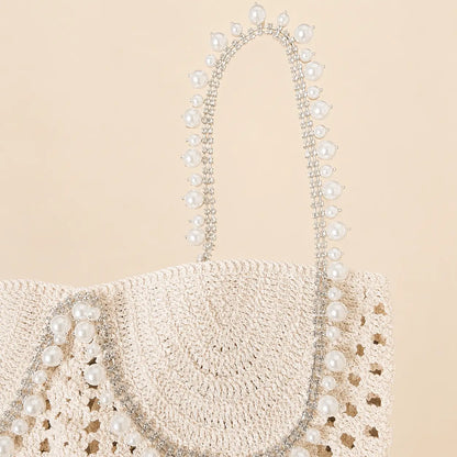 Close up of cream crochet top with pearl and rhinestone strap details