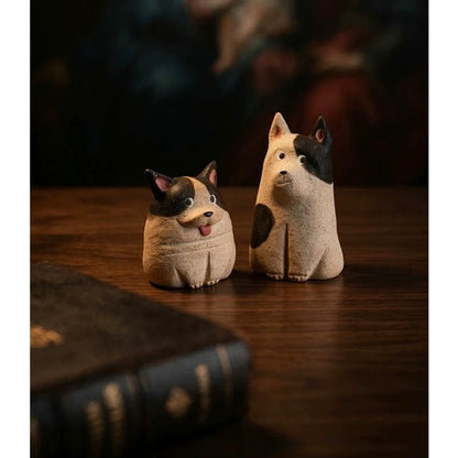 Pair of black and cream dog-shaped aroma stone diffuser figurines displayed on a wooden table