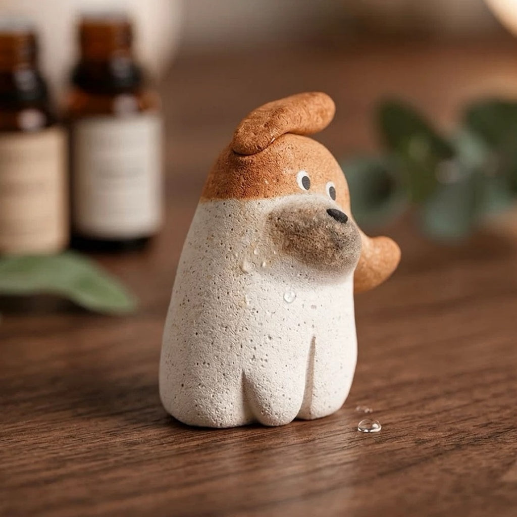 Essential oil being applied with a dropper to a brown dog-shaped aroma stone diffuser