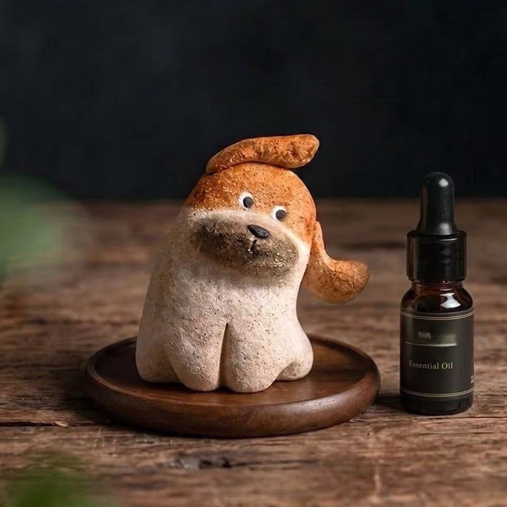 Close-up of a brown and cream dog-shaped aroma stone diffuser on a wooden surface