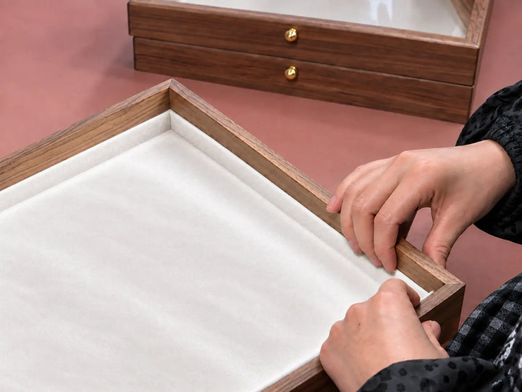 AI-edited illustration of a jewelry-box lining being fitted by hand