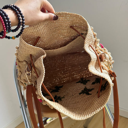 Handwoven floral raffia bucket bag interior with drawstring closure