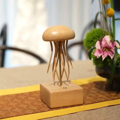 Handcrafted wooden jellyfish art sculpture with curved tentacles and a natural wood finish on a square wooden base.