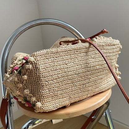 Handwoven natural raffia bucket bag with floral embroidery side view