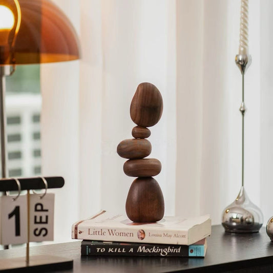 Black Walnut magnetic balance stones displayed on stacked books as modern Zen desk decor
