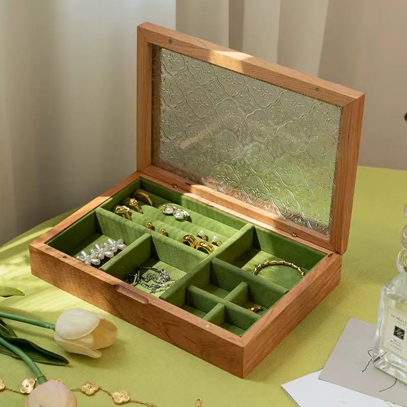 Open cherry wood Maren jewelry box with floral-patterned glass lid, green velvet ring rolls and divided storage.