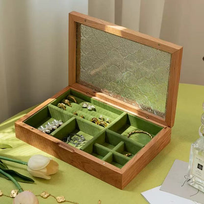 Open cherry wood Maren jewelry box with floral-patterned glass lid, green velvet ring rolls and divided storage.