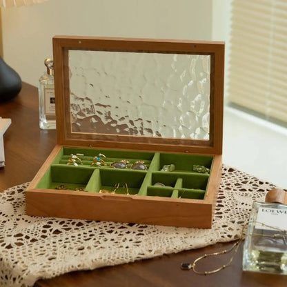 Open cherry wood Maren jewelry box with ripple-patterned glass lid and green velvet compartments.