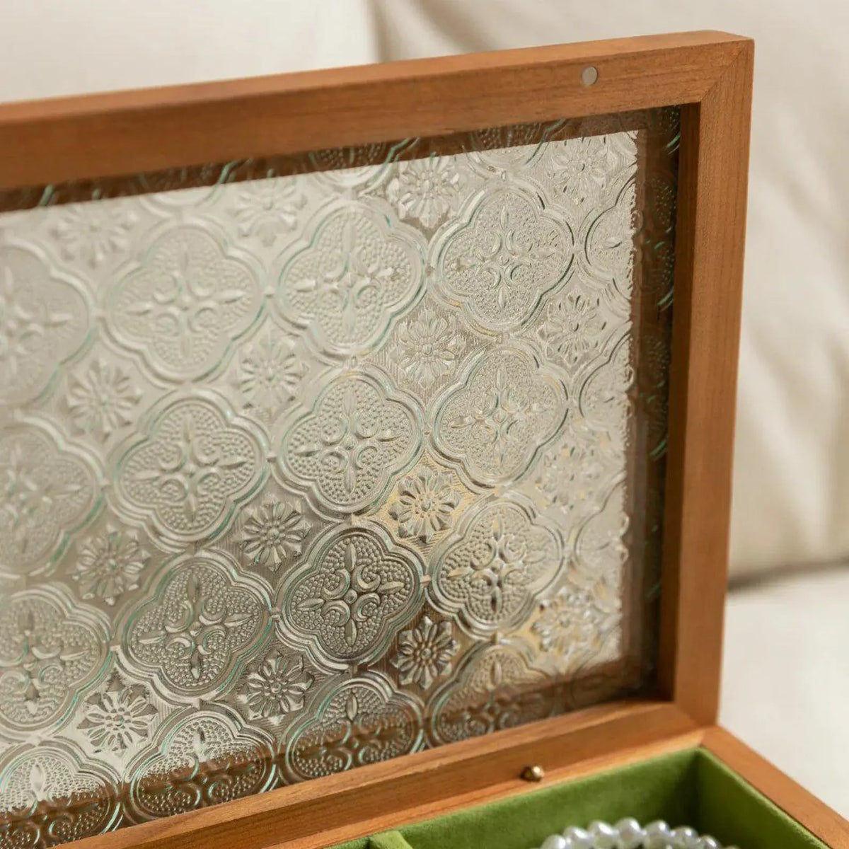 Close-up of the floral-patterned glass panel in a cherry wood jewelry box lid.