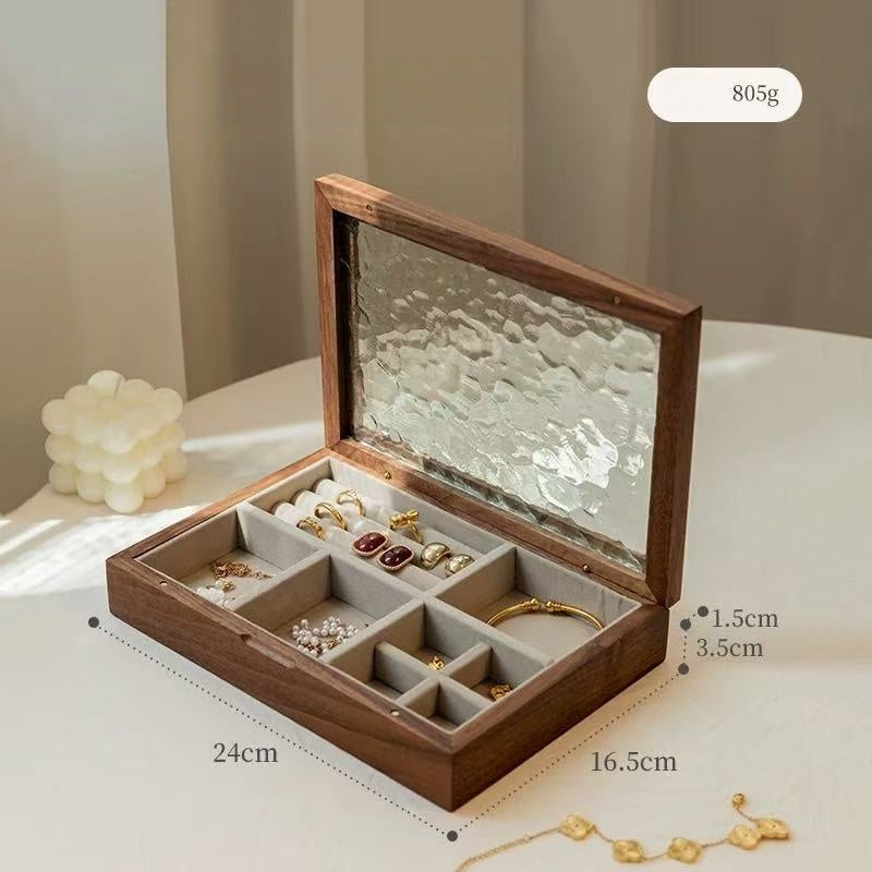 Open black walnut Maren jewelry box with ripple-patterned glass lid and light velvet-lined compartments.