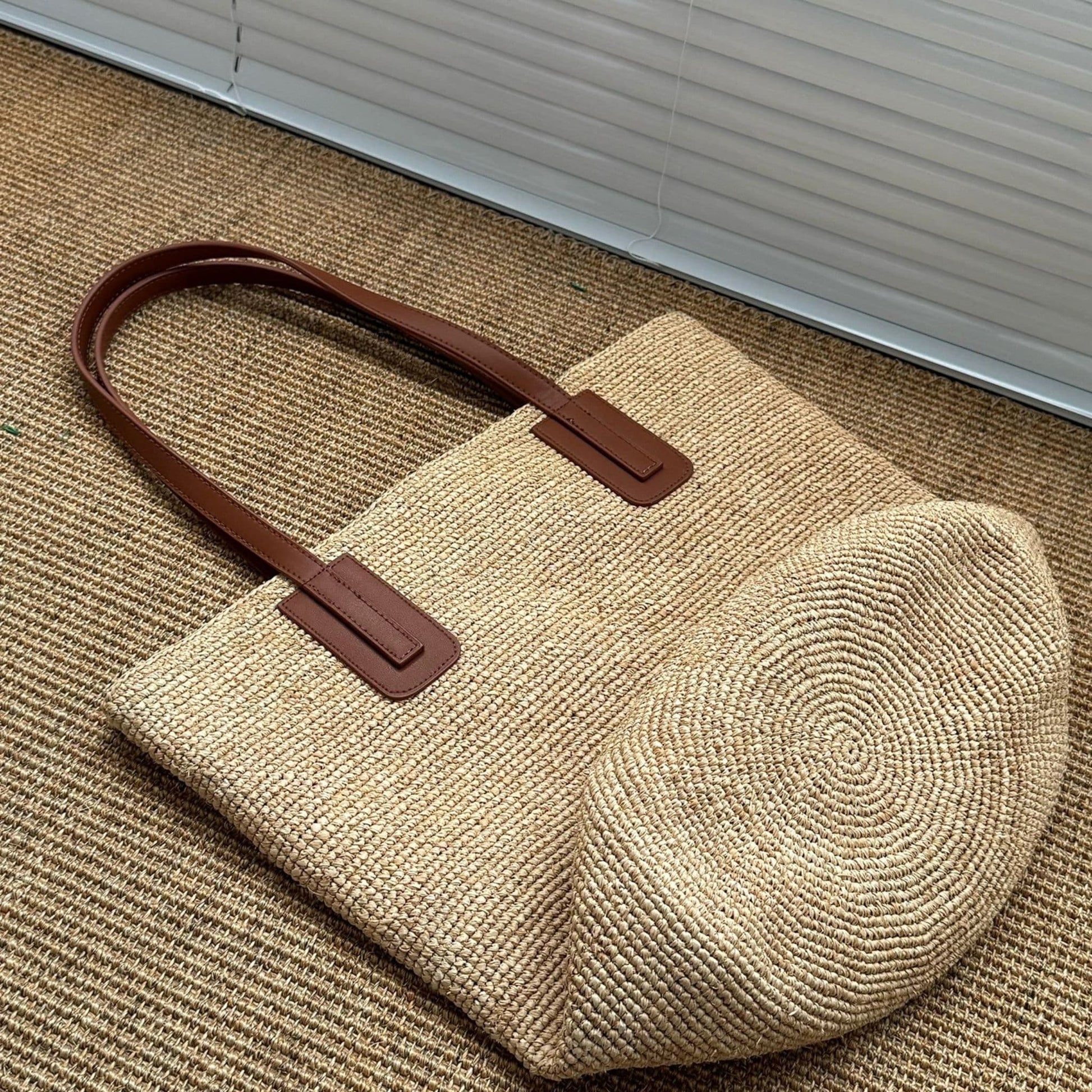 Close-up of circular woven bottom on handmade natural raffia tote bag