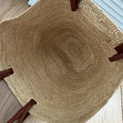 Interior view of a handmade raffia tote bag, highlighting the spacious handwoven basket design and natural raffia craftsmanship.