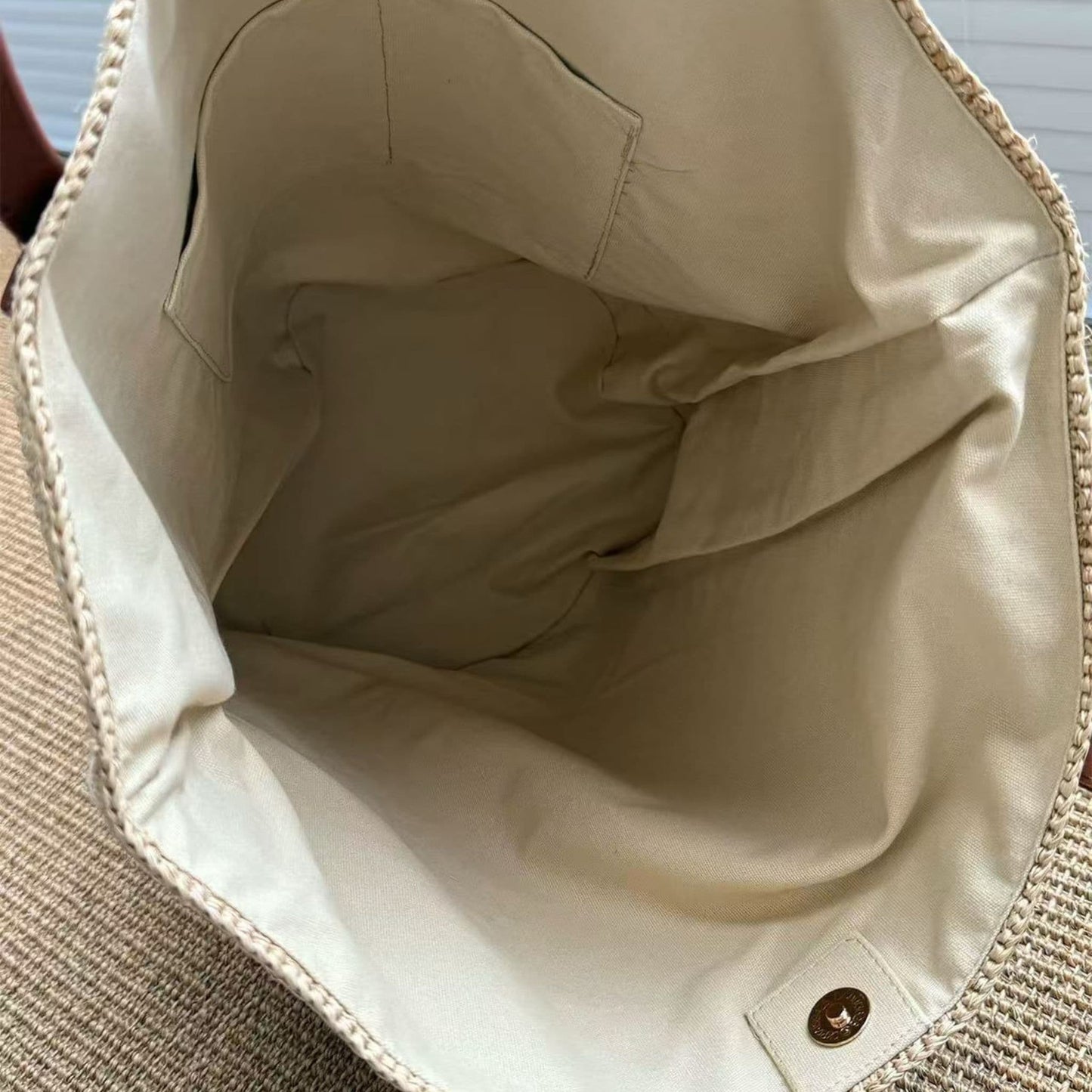 Interior view of handmade raffia tote bag with fabric lining and pocket