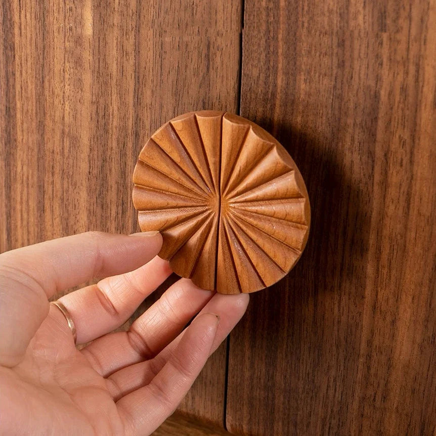 Close-up of the sunflower-shaped door handle and natural wood grain on the Solaris jewelry box