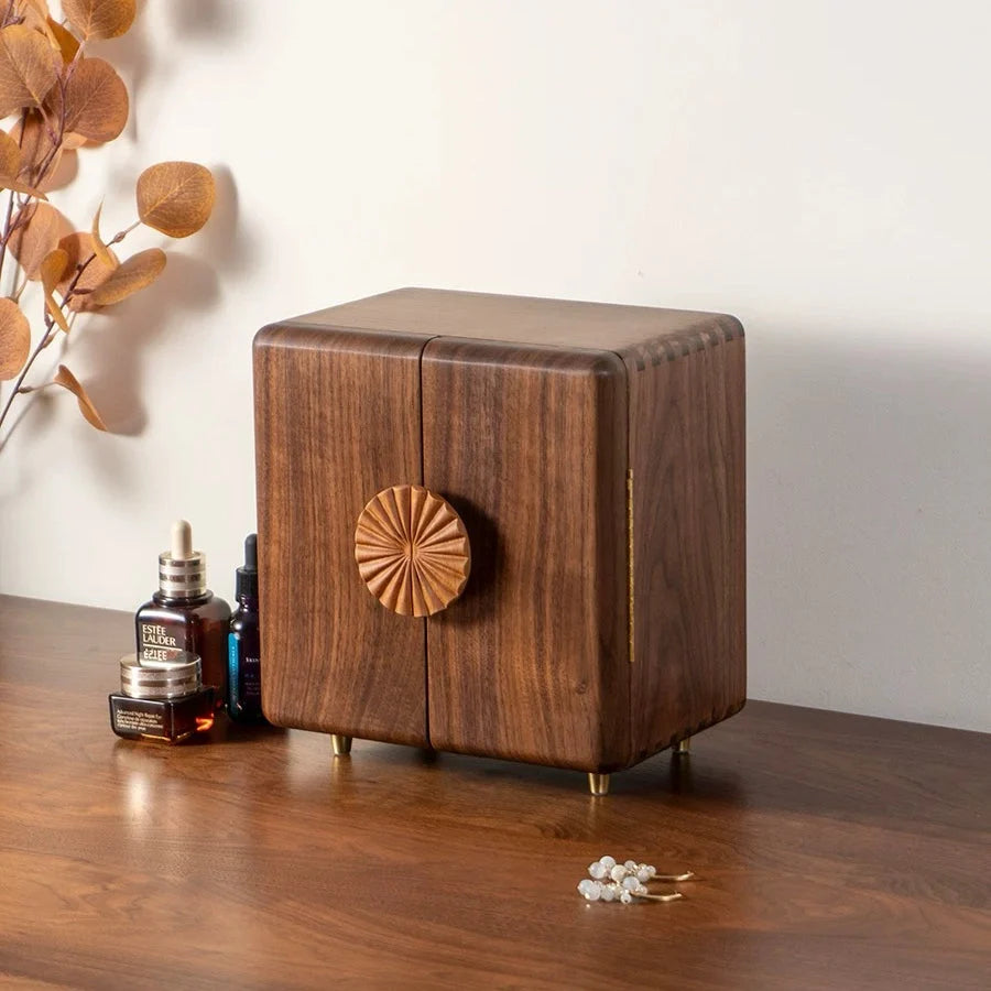 Solaris walnut jewelry box with double doors and a sunflower-shaped handle on a wooden dresser
