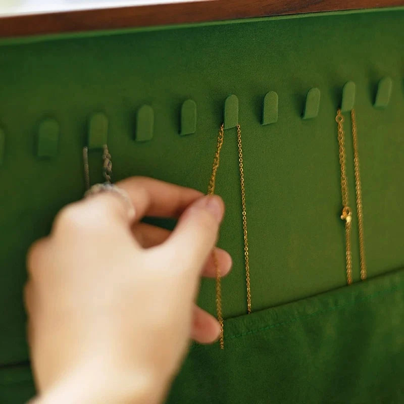 Necklace hooks and a green velvet storage pocket inside the Sylvan jewelry box lid