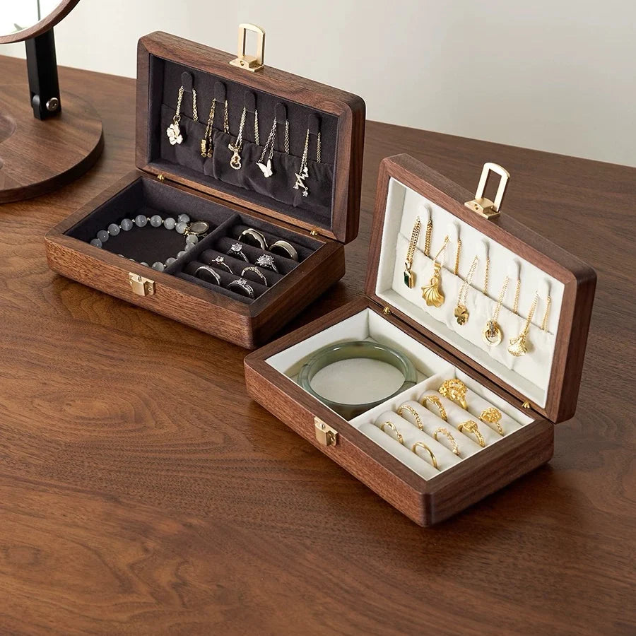Two single-layer walnut jewelry boxes showing dark gray and ivory velvet lining options.
