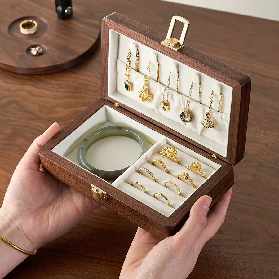 Open single-layer walnut jewelry box with ivory velvet lining, necklace hooks, ring rolls and a bracelet compartment.