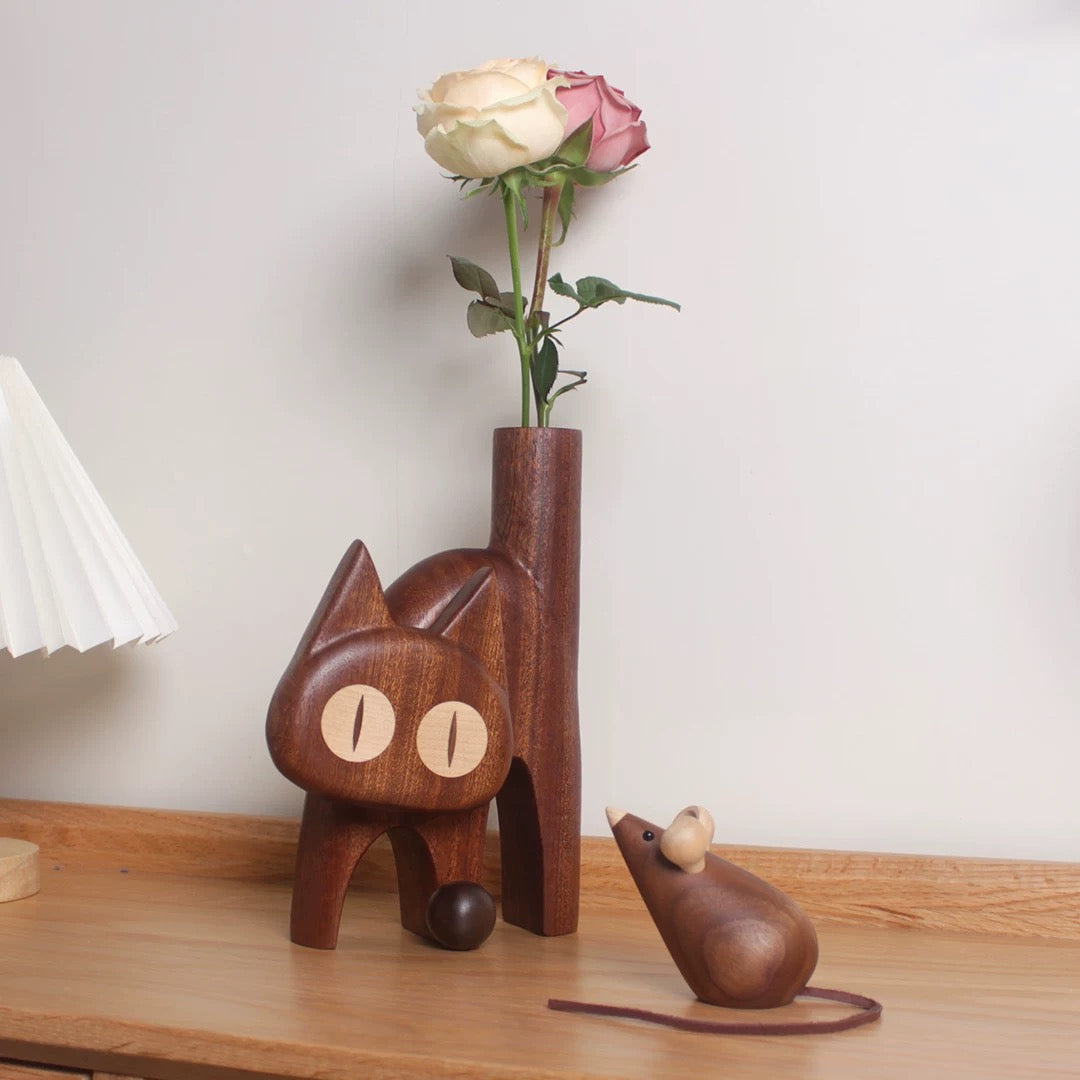 Dark wenge cat vase with fresh roses styled as playful tabletop decor.