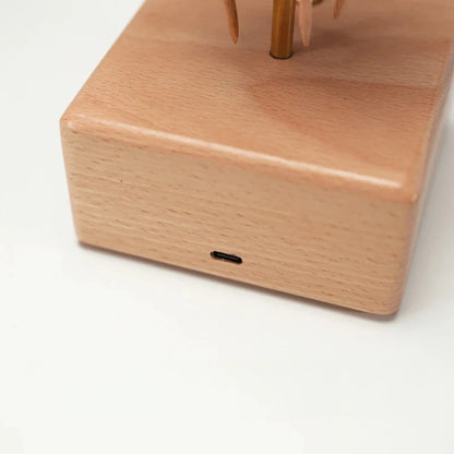 Close-up of the charging port on the wooden base of the jellyfish kinetic sculpture.