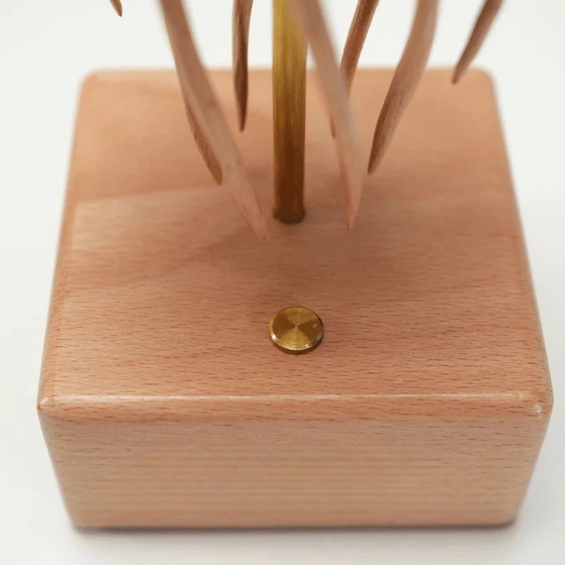Close-up of the power button on the wooden base of the jellyfish kinetic sculpture.