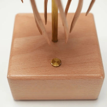 Close-up of the power button on the wooden base of the jellyfish kinetic sculpture.