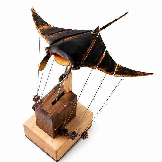 Full view of a handcrafted wooden manta ray automaton with articulated wings and mechanical base on a white background.