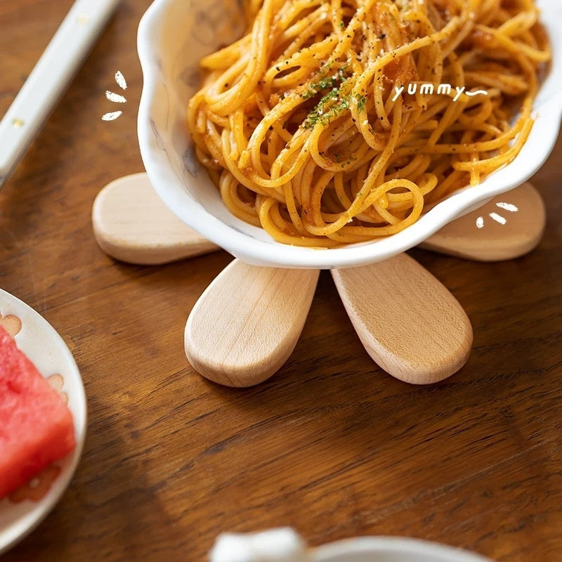 Foldable solid wood trivet opened beneath a serving bowl to help protect the dining table.