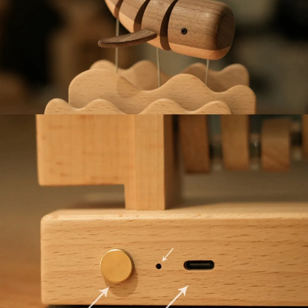 Close-up of handcrafted wooden whale kinetic sculpture and wooden base details